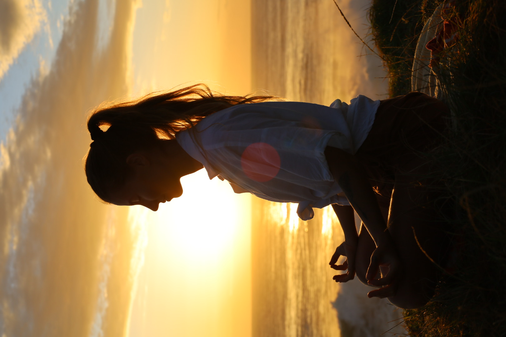 Nic in seated meditation at sunset by the ocean